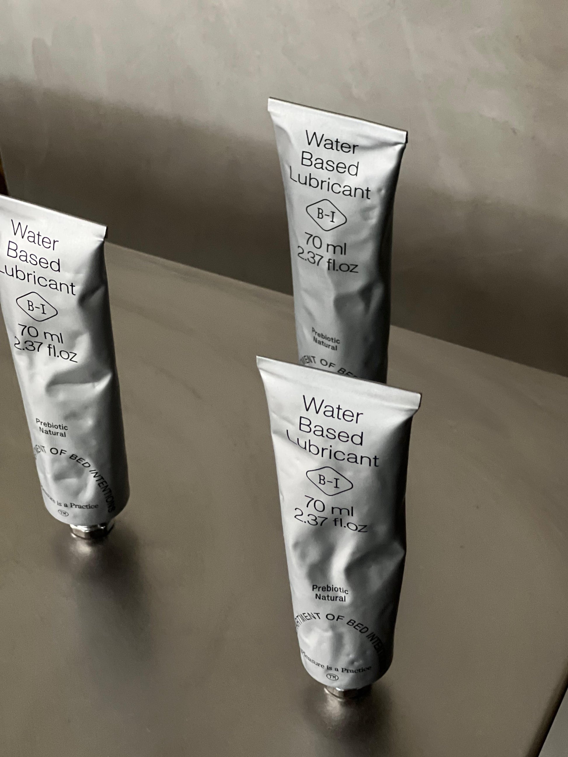 Trio of Prebiotic water-based lubricant on a reflective surface with a neutral background